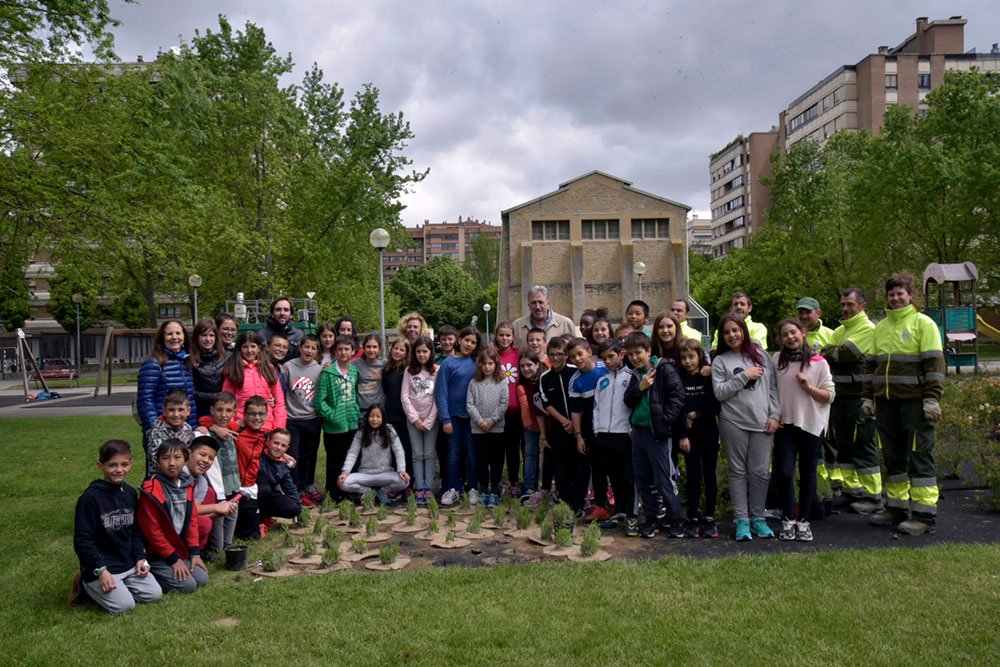 Estudiantes de Primaria de la Ikastola Amaiur dan el remate final a su Paloma, el motivo del parterre diseñado para Iturrama dentro del programa Barrios de colores